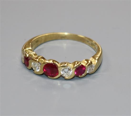 A modern 18ct gold, ruby and diamond seven stone half hoop ring, size M.